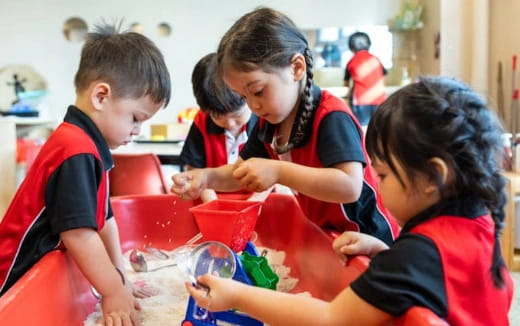 a group of children in red aprons