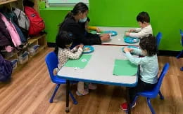 a group of children sitting around a table