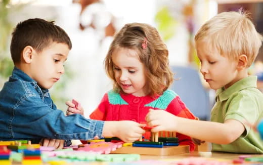 a few children looking at a book