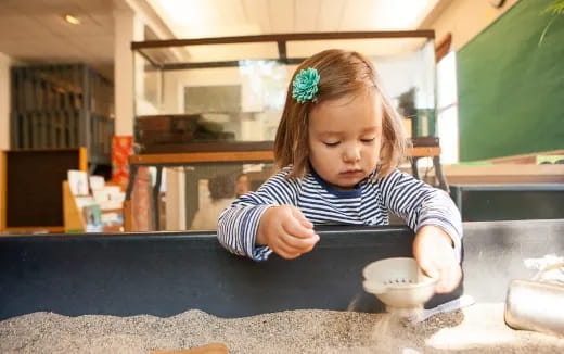 a little girl sitting at a table