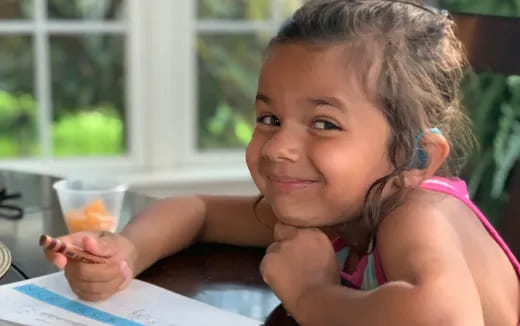 a girl holding a pencil