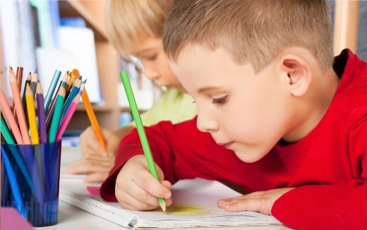 a young boy writing on a paper