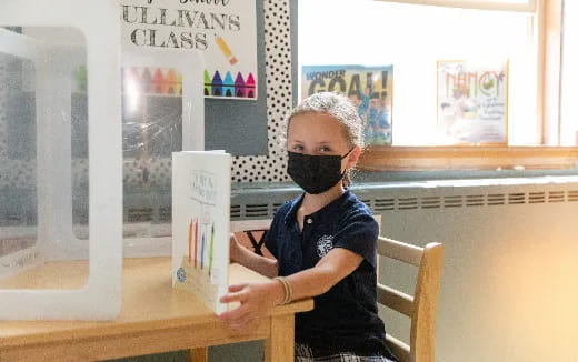 a person sitting at a table with a box on their head