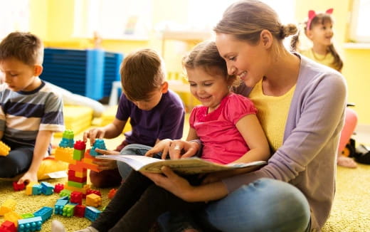 a person reading a book to children