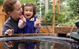a boy and girl looking at a metal fence