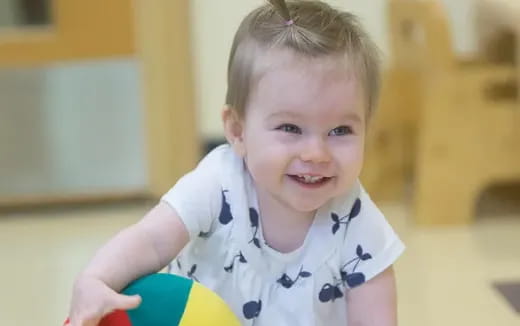 a baby holding a ball
