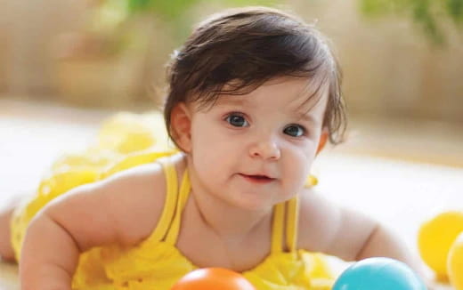 a baby in a yellow shirt