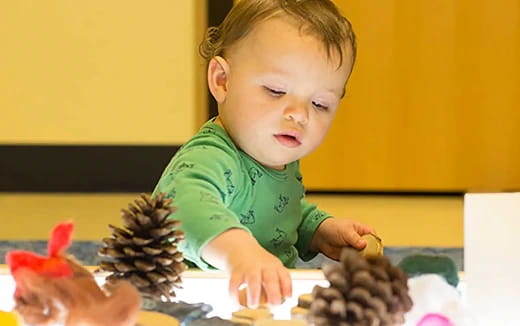 a baby looking at a toy