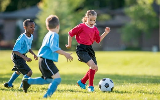 kids chasing a football ball