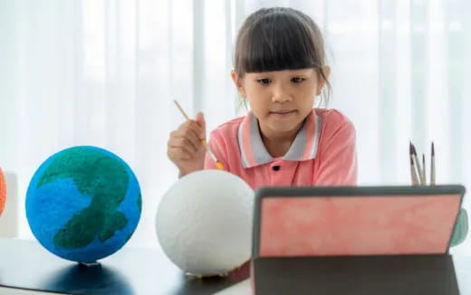 a young girl sitting at a desk