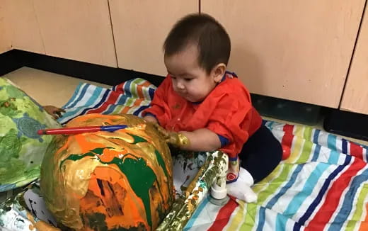 a baby playing with a colorful blanket