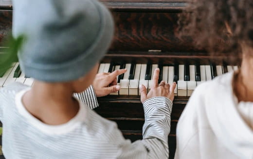 a couple of people playing piano