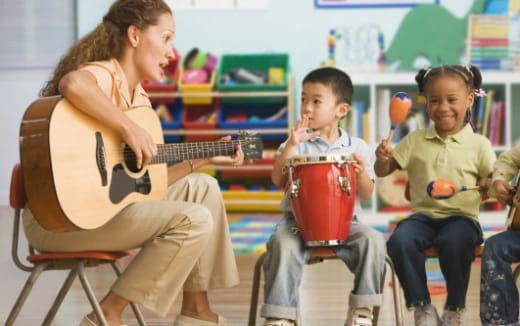 a person playing guitar to kids