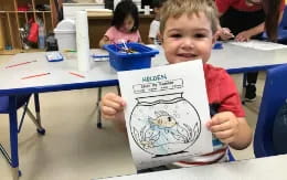 a boy holding a drawing