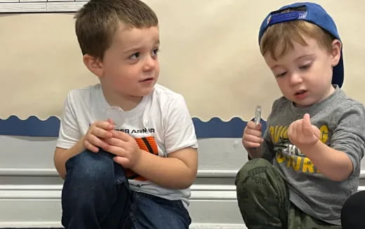 two boys sitting on a bench