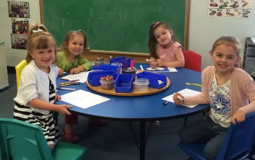 a group of children sitting around a table