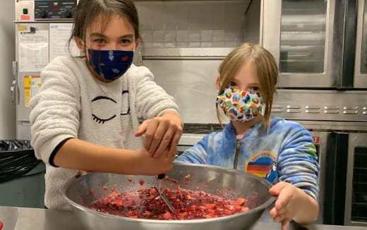 a couple of kids wearing masks and eating food
