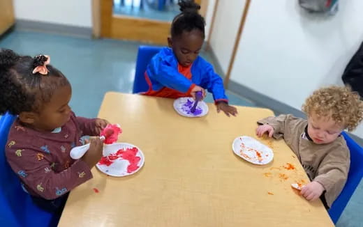 a group of children sitting at a table eating food