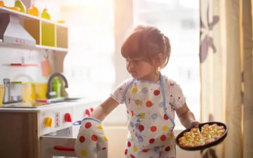 a little girl holding a pizza