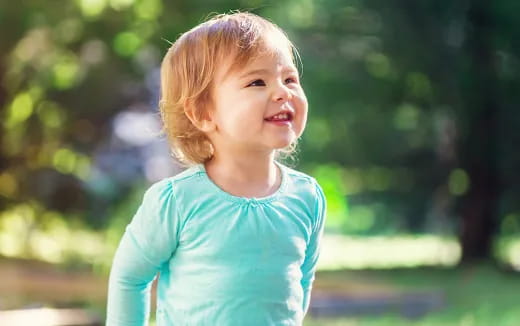 a child smiling outside