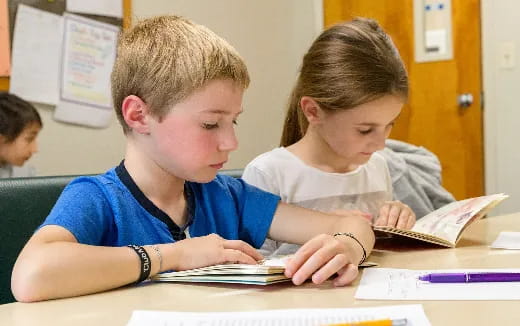 a few children studying in a classroom