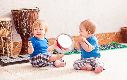 two babies sitting on the floor