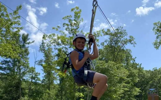 a person wearing a helmet and harness holding a rope