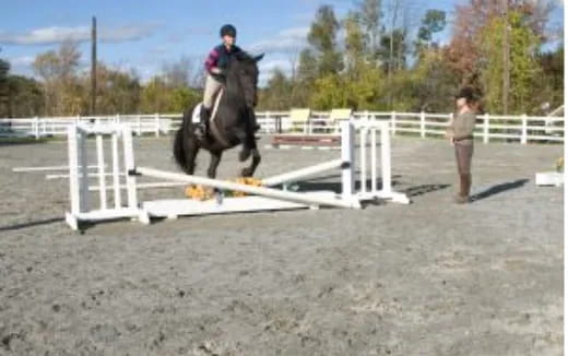 a person riding a horse over a jump