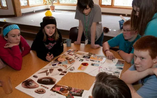 a group of children sitting around a table playing a board game