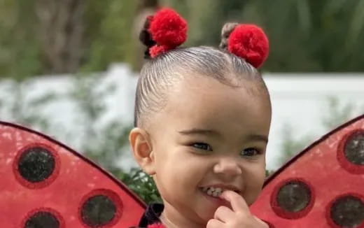 a baby with a red flower on its head