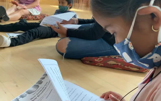 a group of children sitting on the floor reading books