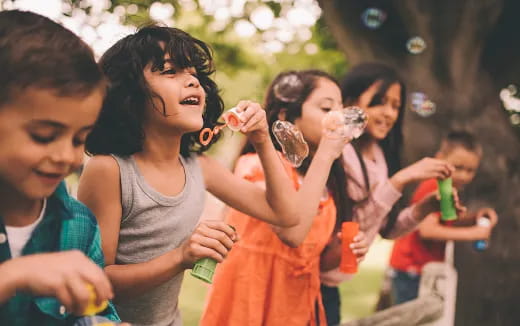 a group of children playing with bubbles