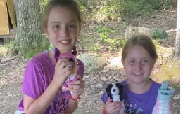 a couple of girls holding a stuffed animal