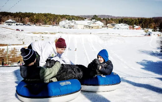 a person and a child on a sled in the snow