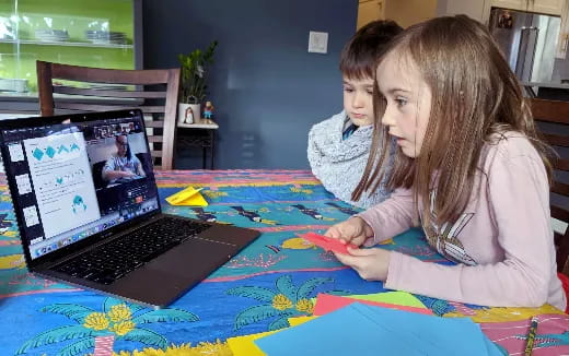 a person and a girl looking at a laptop