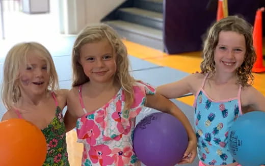 a group of girls holding balloons