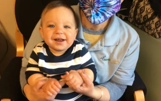 a baby holding a person's hand