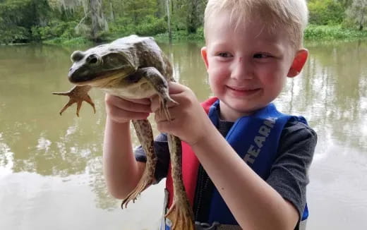 a boy holding a fish