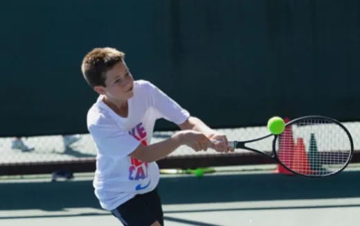 a boy playing tennis