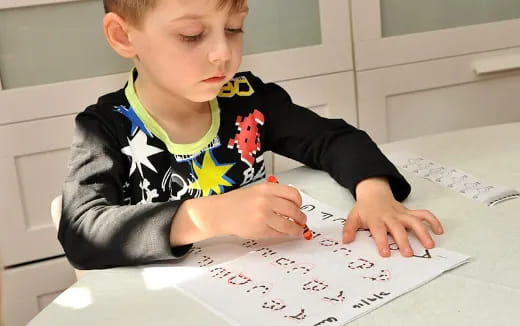 a child writing on a piece of paper