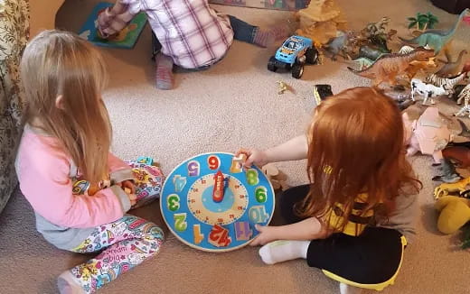 a couple of young girls playing with a toy