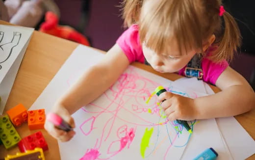 a girl coloring on a paper