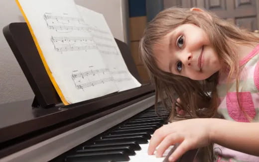 a girl sitting at a piano