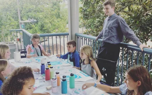 a group of children sitting around a table