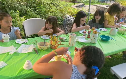 a group of children sitting at a table eating food