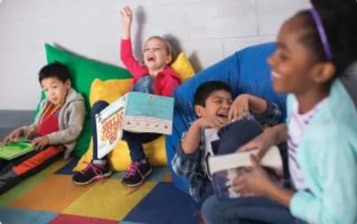 a group of children sitting on the floor and holding books