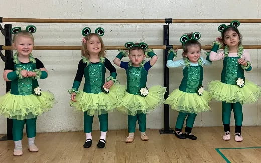 a group of girls in green dresses