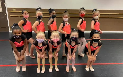 a group of girls in leotards posing for a photo