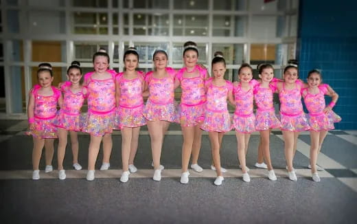 a group of girls in pink and white dresses