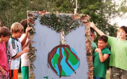 a group of kids holding a tree